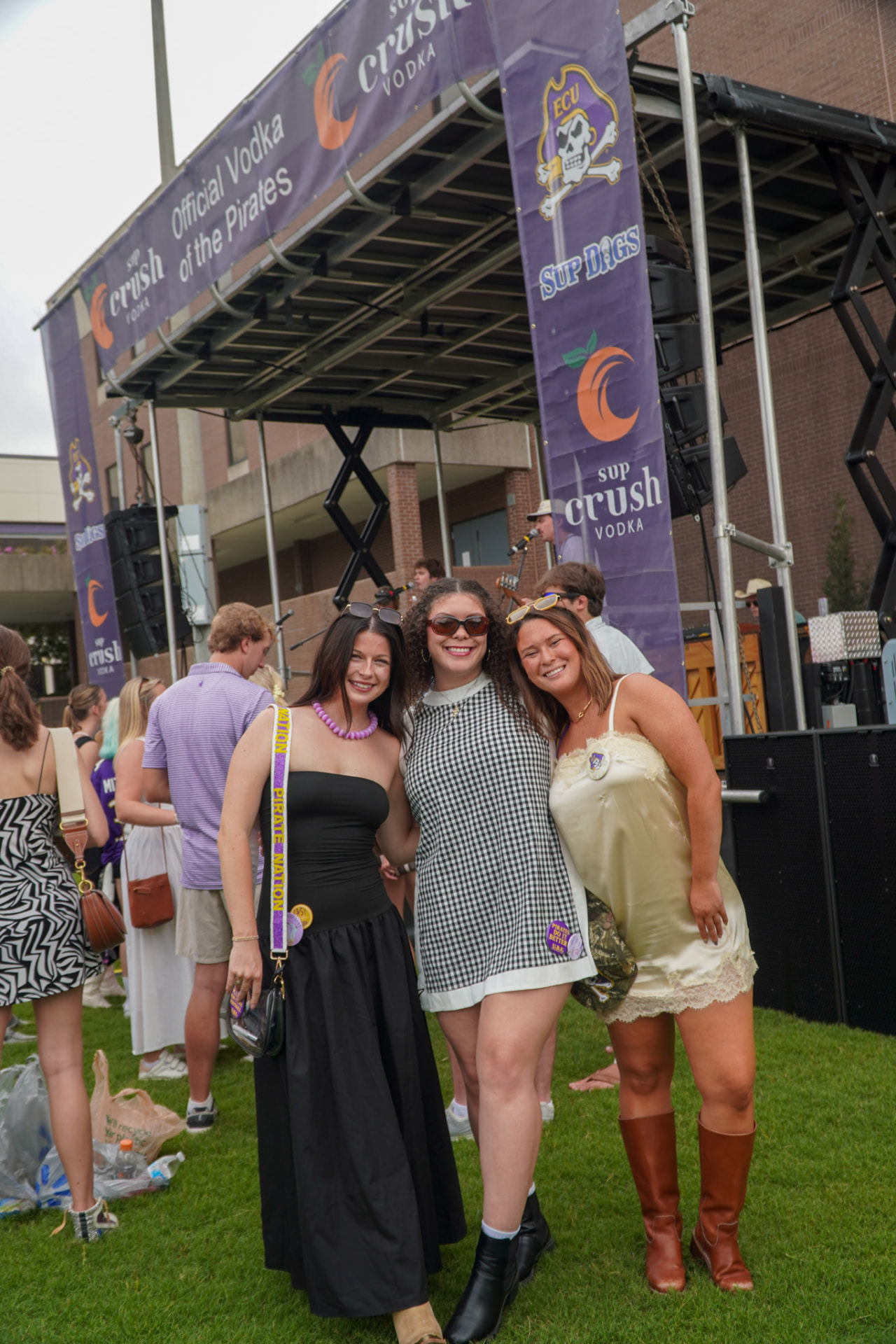 Three women smiling together at an outdoor event