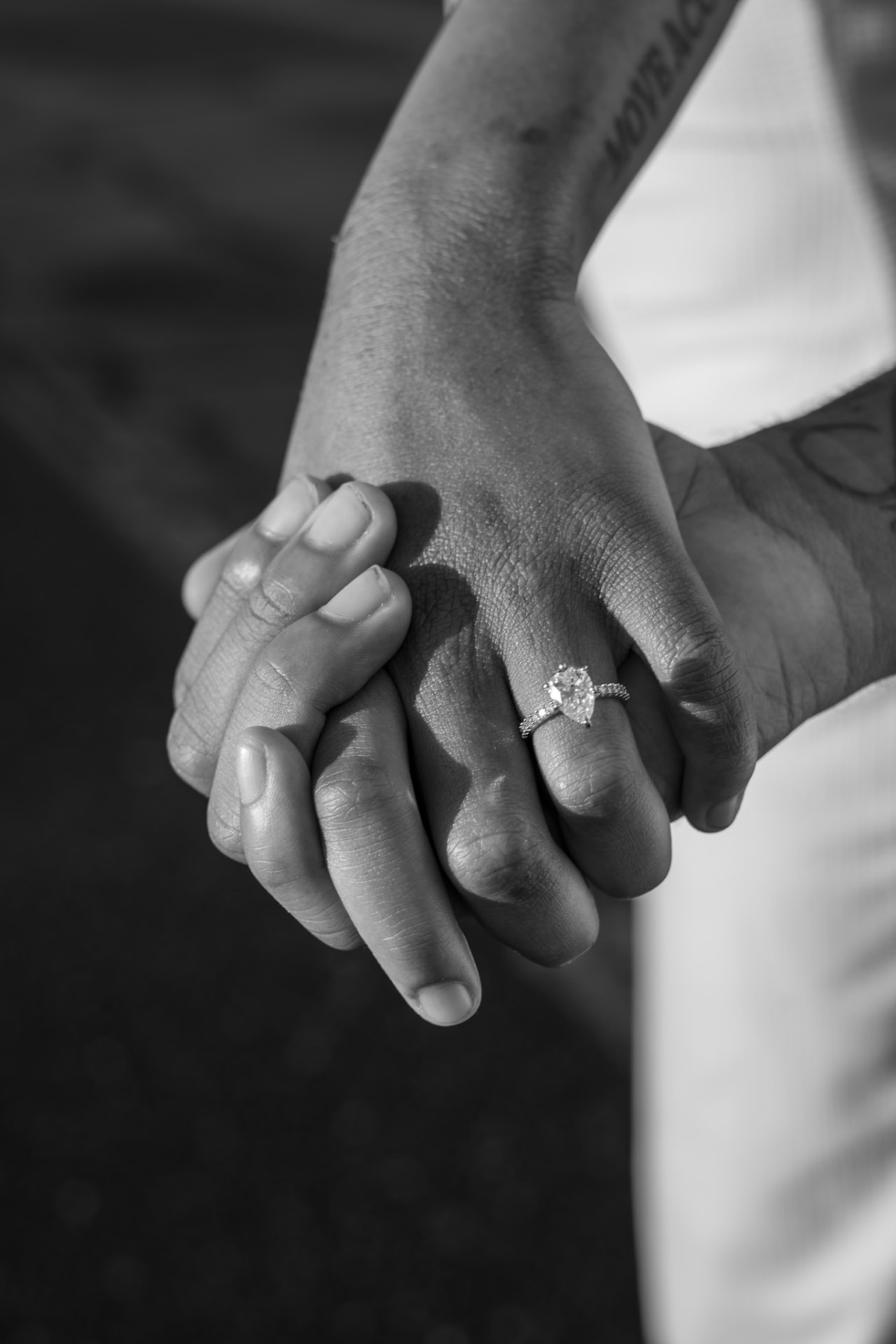 Hands intertwined with an engagement ring